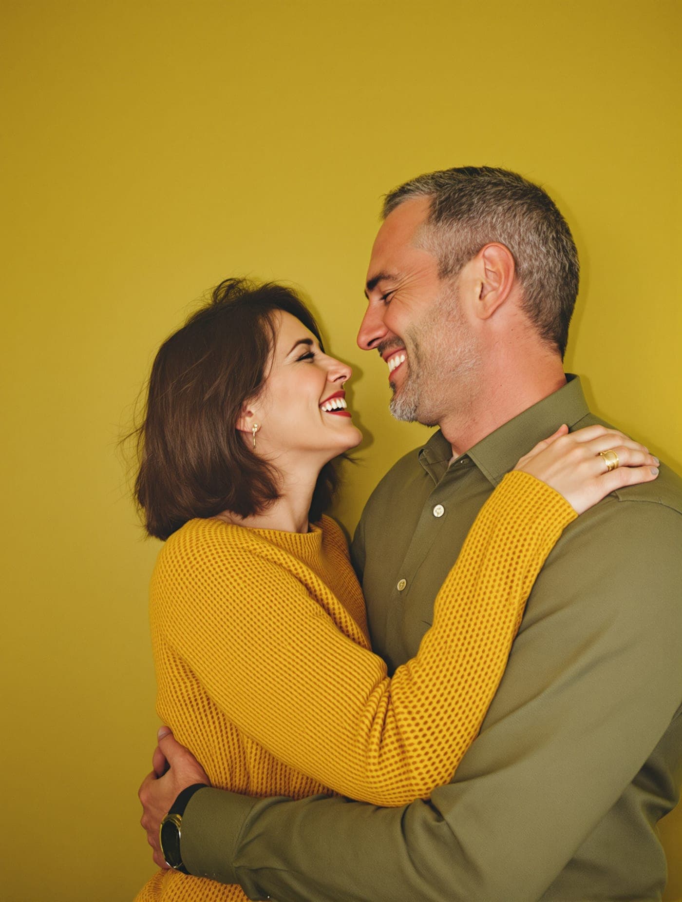 A couple in their forties embracing and laughing together.